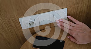 Woman hand presses on turn off lights closeup