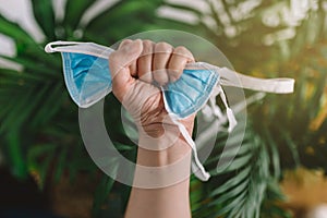 Woman hand pressing a blue breathing medical respiratory mask. waiting for the epidemic to end. Chinese pandemic coronavirus,