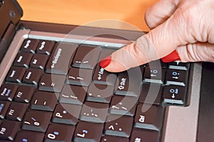 Woman hand pressing `enter` button on computer