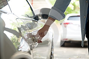 Woman hand pulling car door handle to open the a car