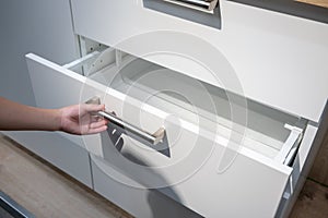 Woman hand pulling a drawer organized with additional plastic