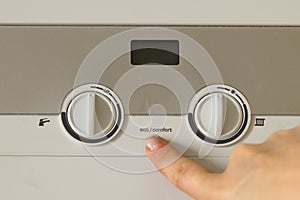 Woman hand push an installation button of home gas heating boiler