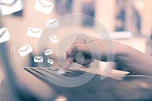 Woman hand push key button on her laptop to send email. photo