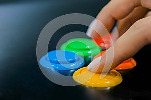 Woman hand pushing bright buttons on retro arcade game machine - close up view