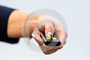 Woman hand pushing button on remote control car key, close-up