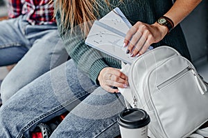 Woman hand put a boarding pass in bag. Hand holding tickets. Waiting for aircraft and travel