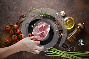 Woman hand put meat on to iron pan for preparation to marinate on ingredients background. top view, horizontal image