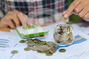 Woman hand putting coinIn the glass jar. Saving money wealth and financial concept, Personal finance, finance management, savings