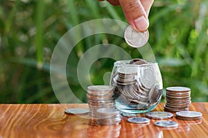 Woman hand putting coinIn the glass jar. Saving money wealth and financial concept, Personal finance, finance management, savings photo