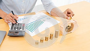 Woman hand putting money coin into piggy bank with step of growing stack coins for saving money for future investment concept