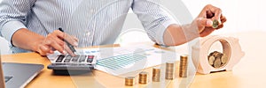 Woman hand putting money coin into piggy bank with step of growing stack coins for saving money for future investment concept