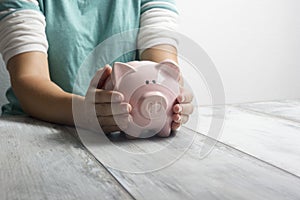 Woman hand putting money coin into piggy for saving money wealth and financial concept.