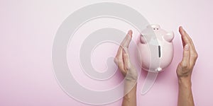 Woman hand putting money coin into piggy for saving money wealth and financial concept.