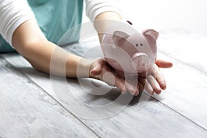 Woman hand putting money coin into piggy for saving money wealth and financial concept