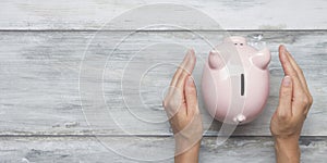 Woman hand putting money coin into piggy for saving money wealth and financial concept