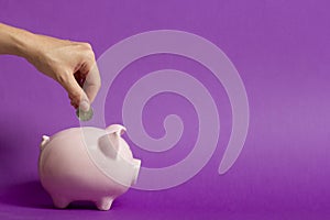 Woman hand putting money coin into piggy for saving money wealth and financial concept