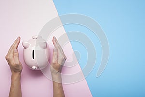 Woman hand putting money coin into piggy for saving money wealth and financial concept.