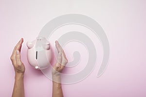 Woman hand putting money coin into piggy for saving money wealth and financial concept