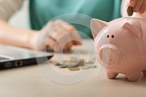 woman hand putting money coin into piggy for saving money wealth and financial concept