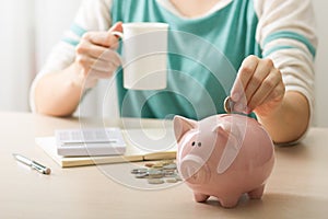 woman hand putting money coin into piggy for saving money wealth and financial concept