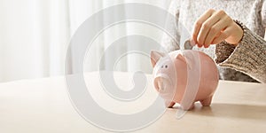 woman hand putting money coin into piggy for saving money wealth and financial concept