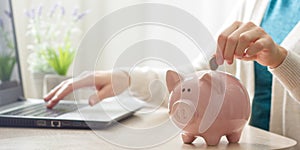 woman hand putting money coin into piggy for saving money wealth and financial concept