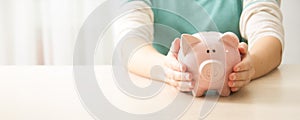 woman hand putting money coin into piggy for saving money wealth and financial concept