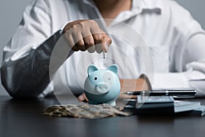 woman hand putting money coin into piggy for saving money wealth and financial concept