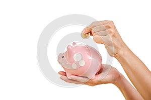 Woman hand putting money coin in to piggy for saving money wealth and financial concept, isolated on the white background