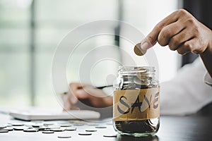 woman hand putting money into jar