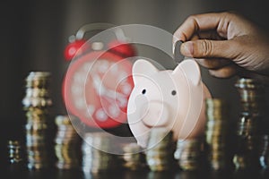 woman hand putting money into piggy