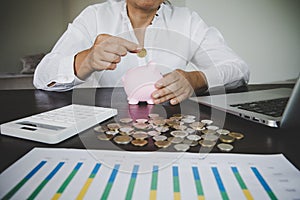 woman hand putting money into piggy