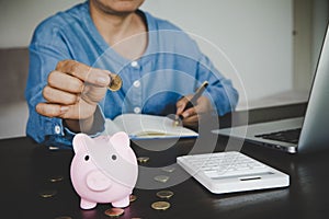 woman hand putting money into piggy