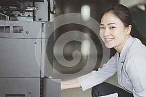 Woman hand putting a sheet of paper into a copying