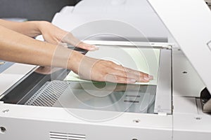 Woman hand putting a sheet of paper into a copying device