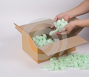 Woman hand putting shockproof foam into the corrugated parcel box