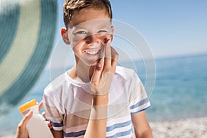 Woman hand putting sun lotion on child face