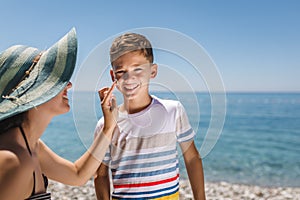 Woman hand putting sun lotion on child face