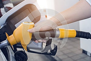 Woman hand refilling and pumping gasoline oil the car with fuel at he refuel station