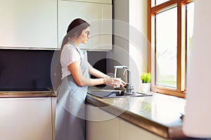 Woman hand& x27;s filling the glass of water