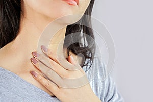 Woman hand self checking thyroid gland on her neck