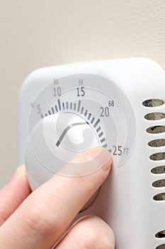 Woman hand setting a thermostat