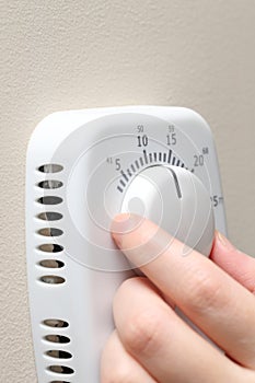 Woman hand setting a thermostat