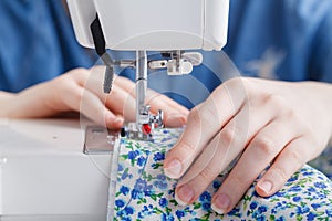 Woman hand sewn fabric on sewing machine.