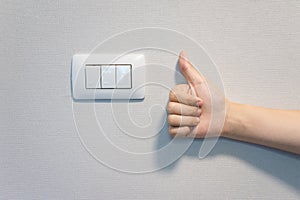 Woman hand show best sign hand with old electrical power light switch. Concept to save electricity