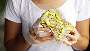 Woman hand show eating avocado bread cheese toast white t-shirt