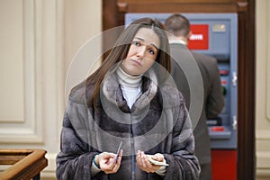 Woman hand showing dollar banknotes in front of the atm