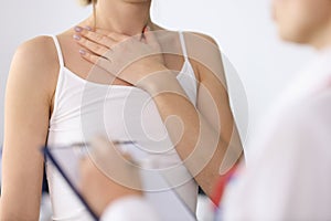 Woman hand showing sore neck at doctor appointment closeup