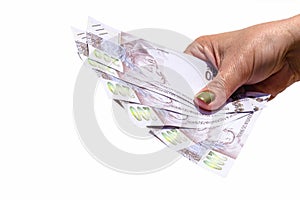 Woman hand showing two hundred reais banknotes on isolated background