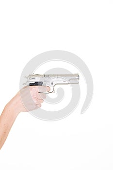 Woman hand with silver gun getting ready to shoot isolated on white background with copy space